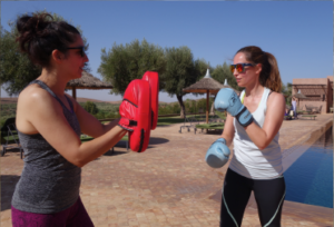 Two woman boxing by a pool
