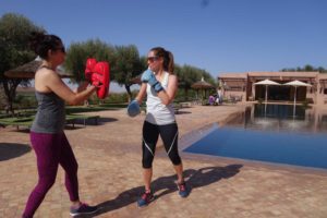 Two women boxing by a pool