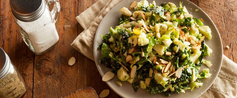Two healthy kale salads served on a traditional table