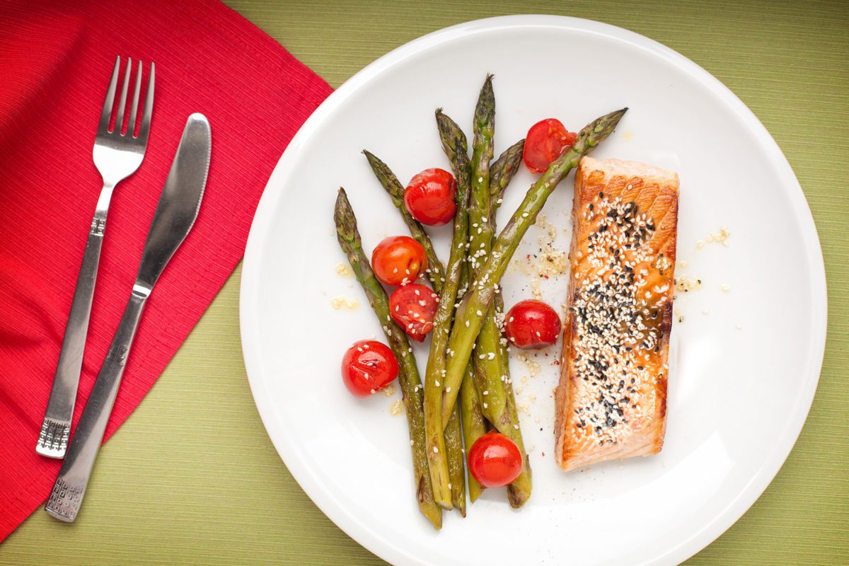 Sesame salmon served with asparagus and tomatoes